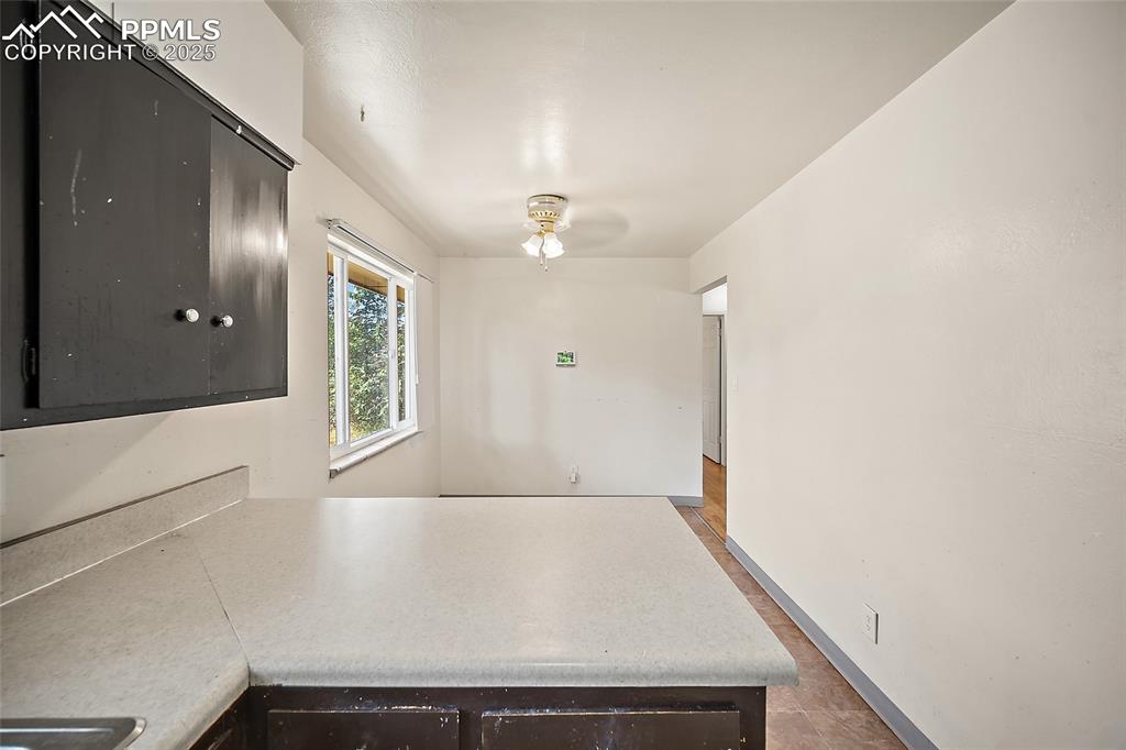 Image 18 of 19: Kitchen with a peninsula, light countertops, dark brown cabinetry, and ceil