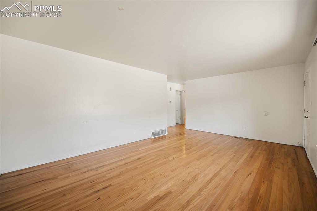 Image 5 of 19: Unfurnished room with light wood-style floors and baseboards