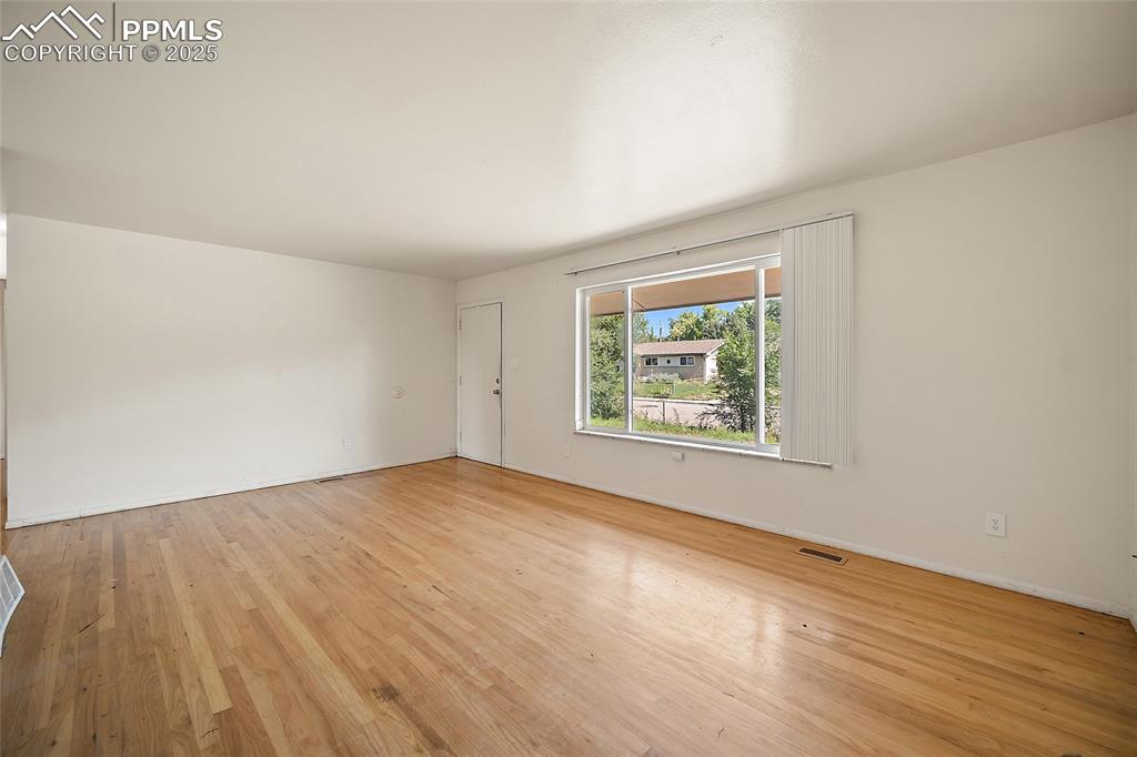 Image 6 of 19: Unfurnished room with light wood-type flooring and baseboards