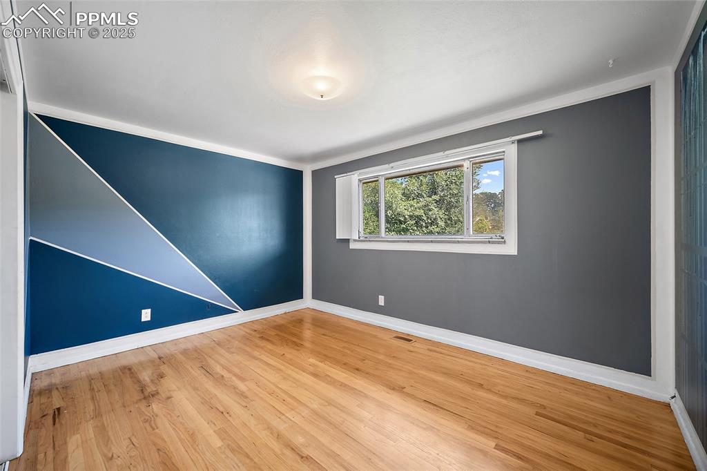 Image 7 of 19: Unfurnished room featuring light wood finished floors and ornamental moldin