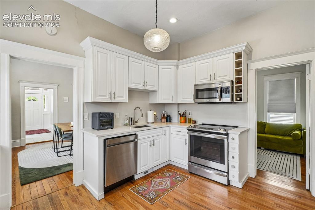 Image 20 of 40: Kitchen with matching stainless steel appliances, wood flooring and plenty