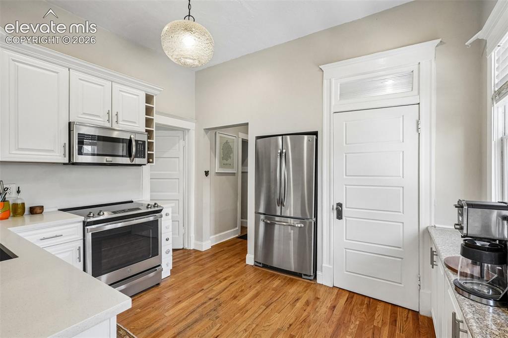 Image 21 of 40: Kitchen with matching stainless steel appliances, wood flooring and plenty