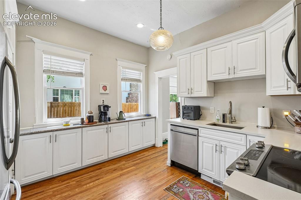 Image 22 of 40: Kitchen with matching stainless steel appliances, wood flooring and plenty