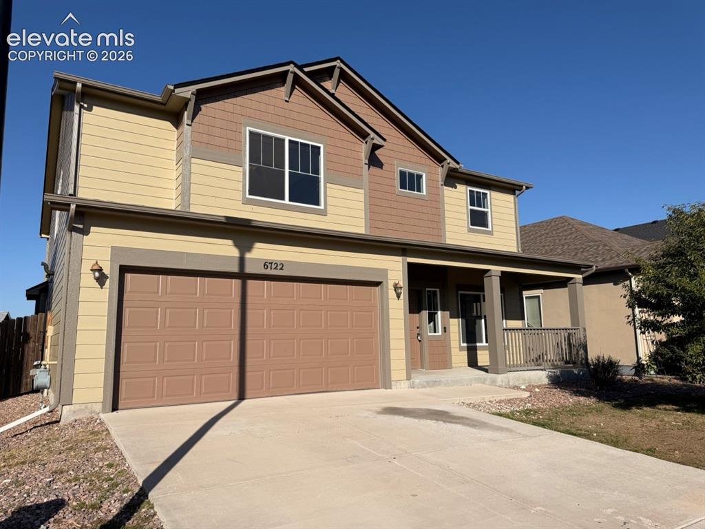 Image 50 of 50: Two-story residence featuring a covered front porch with railings, an attac