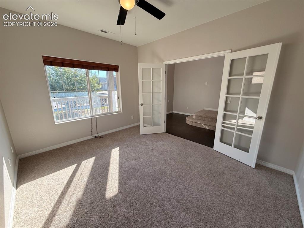 Image 6 of 50: Plush carpet flooring, neutral wall tones, transom window, and white French