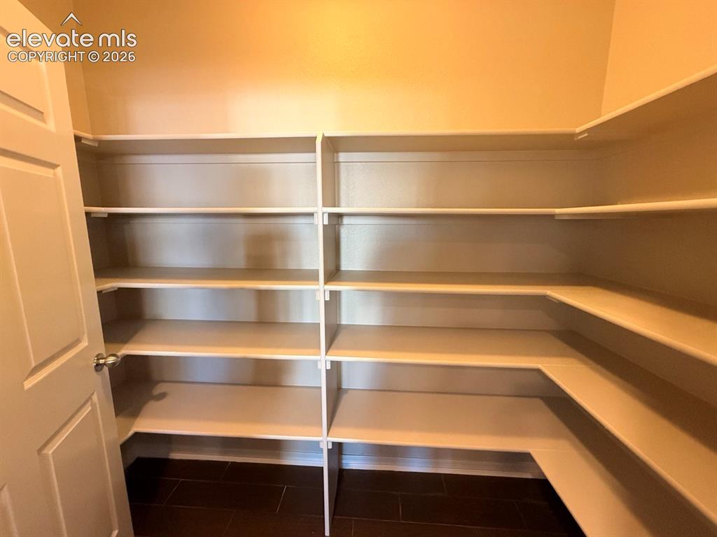 Image 9 of 50: Walk-in pantry with extensive built-in shelving, providing ample storage