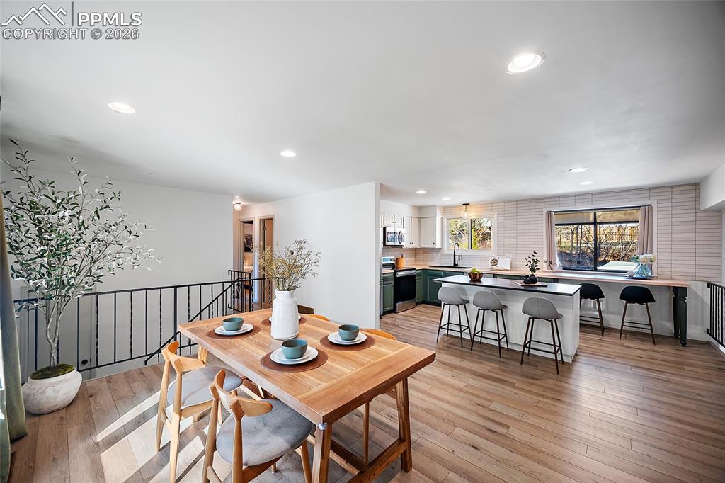 Image 10 of 45: Kitchen featuring green cabinets, stainless steel dishwasher, and backsplas