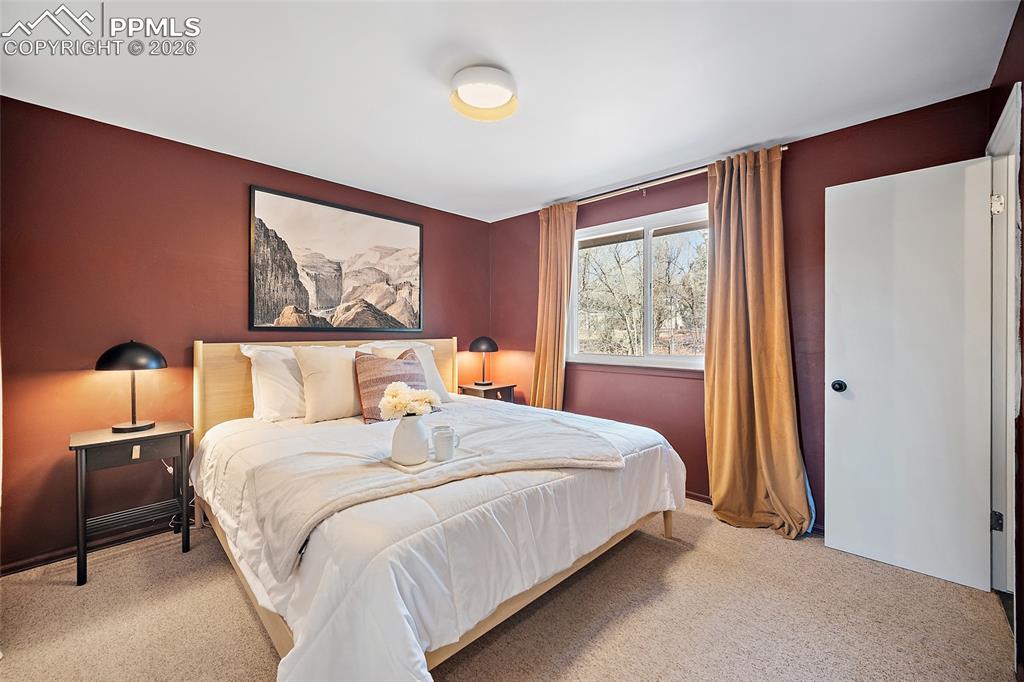 Image 18 of 45: Carpeted living area with stairs and suspended lighting