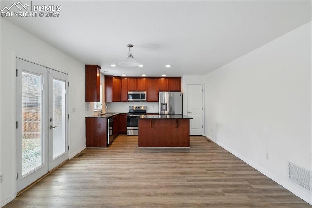 Image 10 of 46: Kitchen featuring appliances with stainless steel finishes, dark countertop
