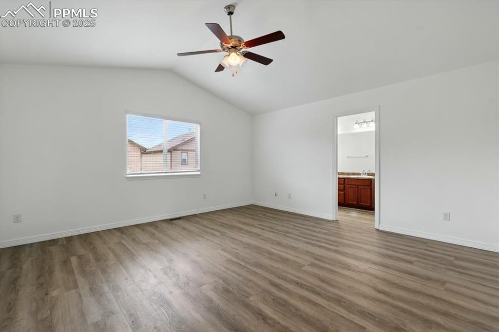 Image 15 of 46: Unfurnished room featuring wood finished floors, vaulted ceiling, a ceiling