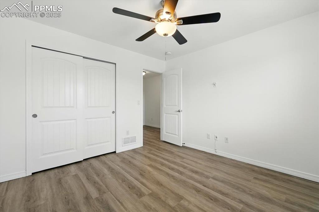 Image 20 of 46: Unfurnished bedroom featuring wood finished floors, a closet, baseboards, a
