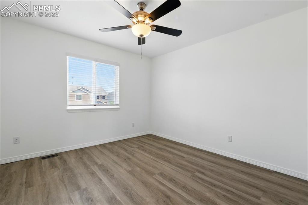 Image 21 of 46: Empty room featuring wood finished floors, baseboards, and a ceiling fan