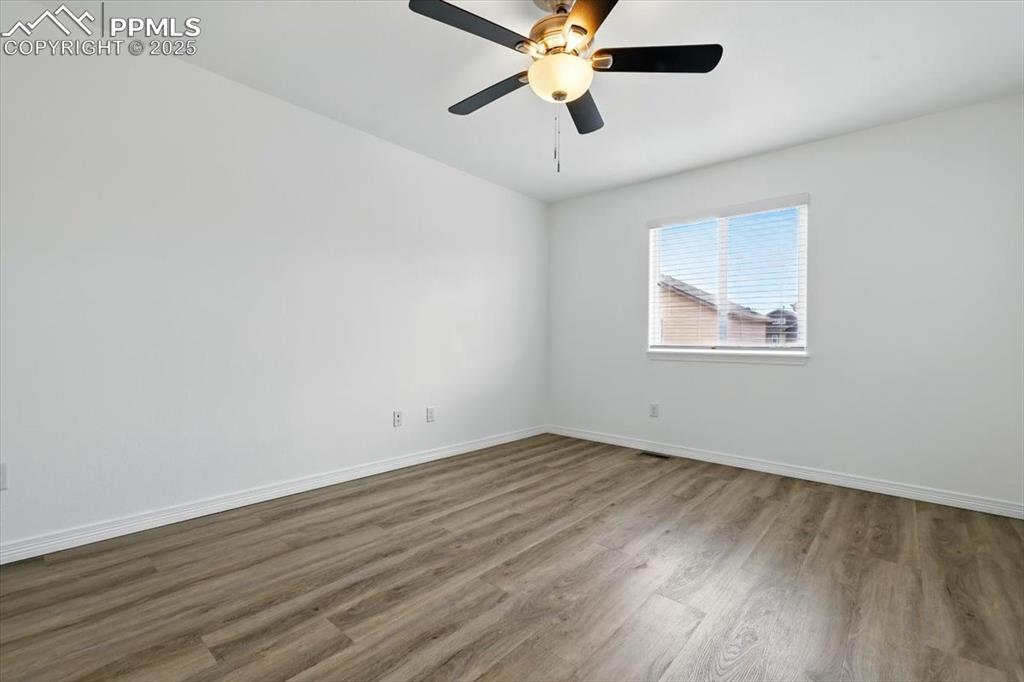Image 22 of 46: Empty room featuring wood finished floors, baseboards, and a ceiling fan