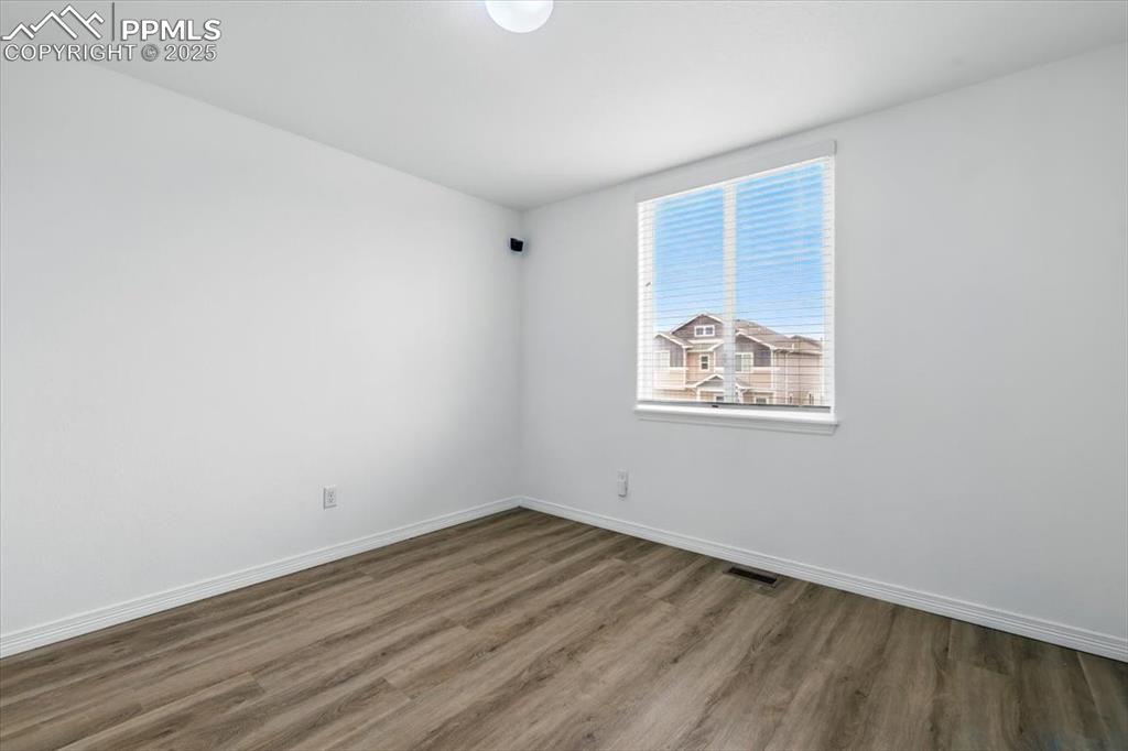 Image 23 of 46: Unfurnished room with wood finished floors and baseboards
