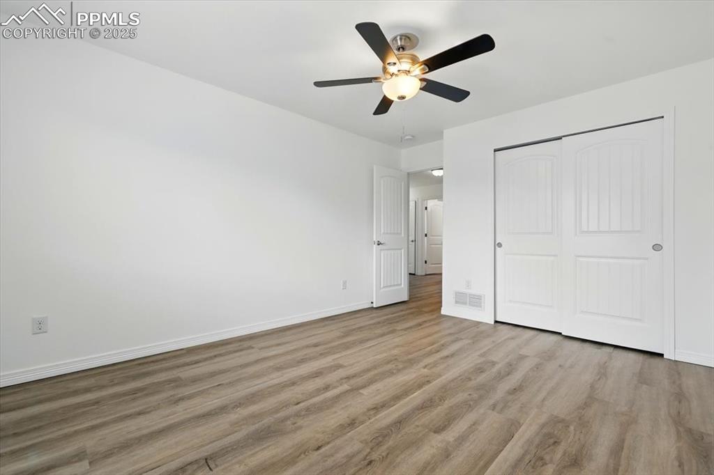 Image 24 of 46: Unfurnished bedroom featuring wood finished floors, baseboards, a closet, a