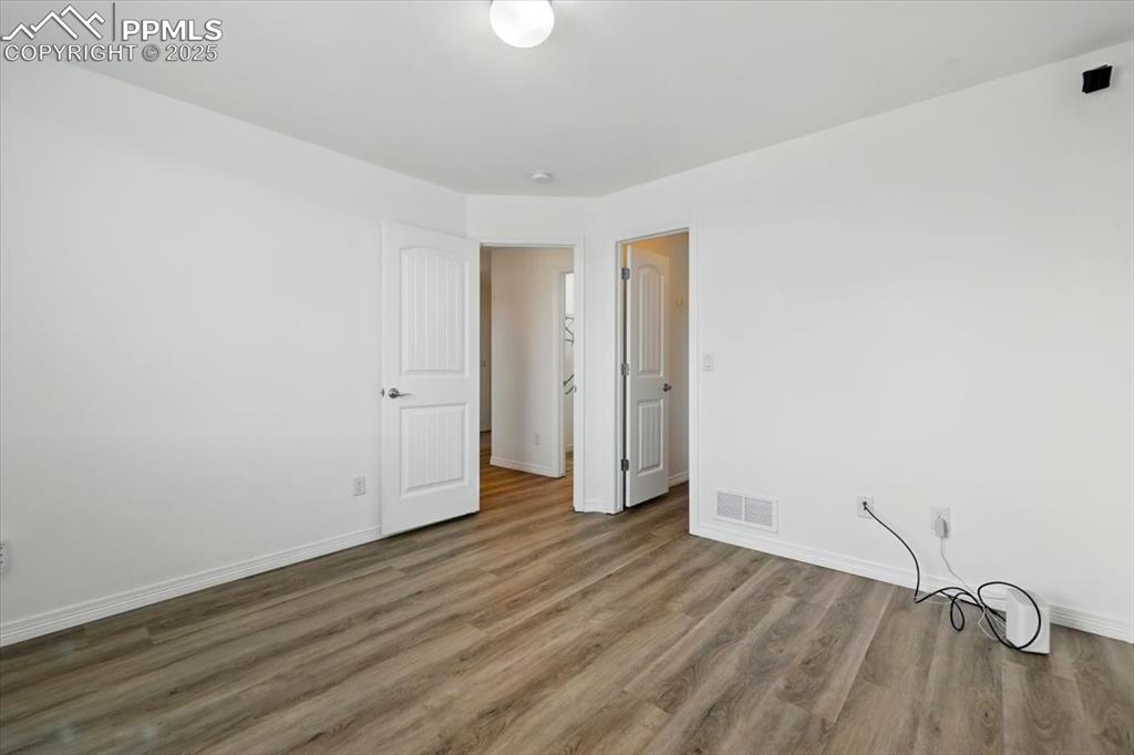 Image 26 of 46: Unfurnished room featuring wood finished floors and baseboards