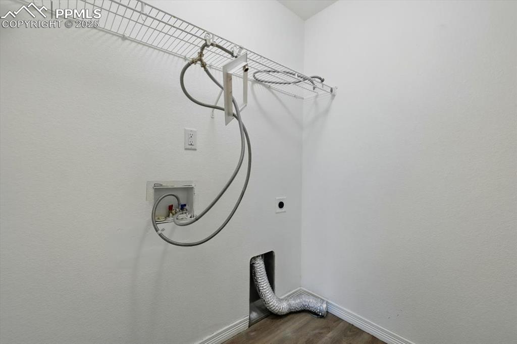 Image 28 of 46: Laundry area featuring dark wood finished floors, hookup for an electric dr