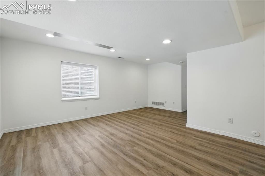 Image 33 of 46: Empty room featuring recessed lighting, wood finished floors, and baseboard