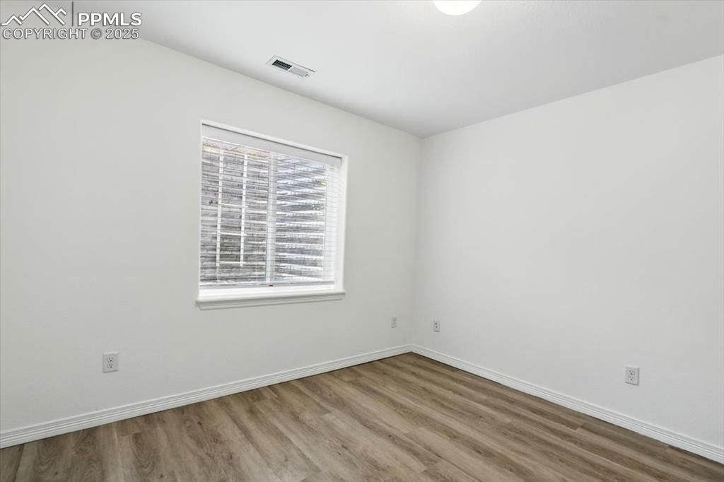 Image 34 of 46: Unfurnished room featuring wood finished floors and baseboards
