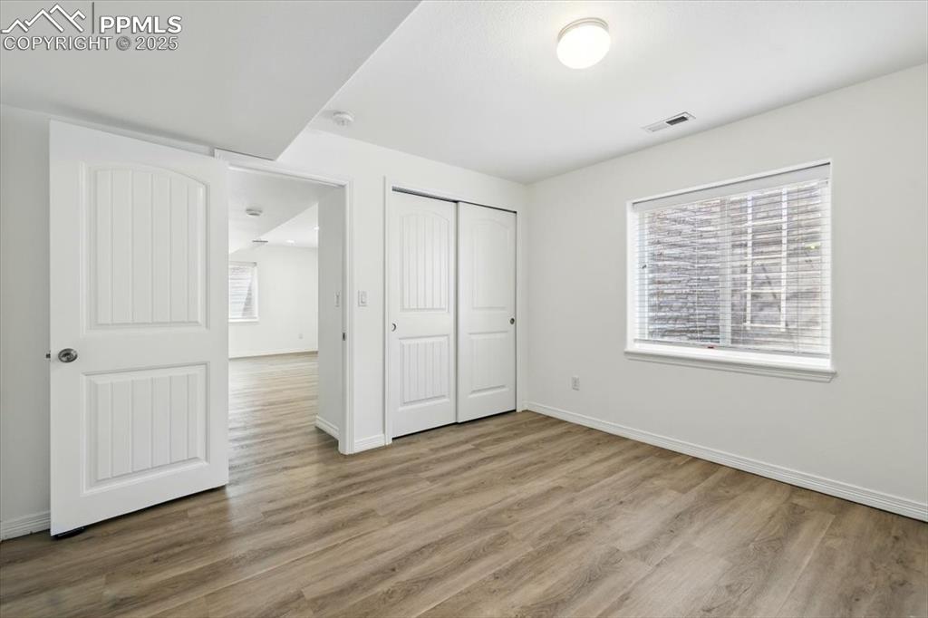 Image 35 of 46: Unfurnished bedroom featuring wood finished floors, baseboards, and a close