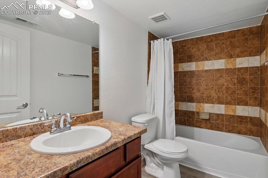 Image 36 of 46: Full bath with vanity, toilet, and shower / bath combination with curtain