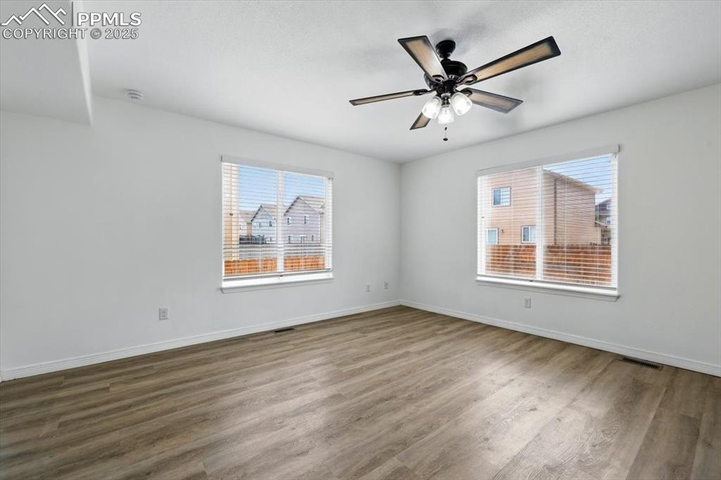 Image 7 of 46: Spare room featuring wood finished floors, baseboards, a ceiling fan, and a