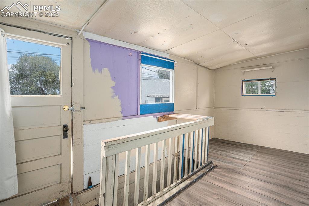 Image 8 of 12: Extra room at back of house that leads to basement and back yard