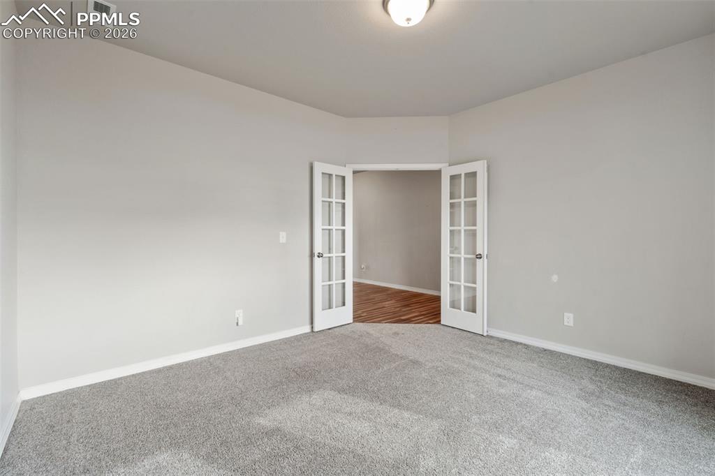 Image 10 of 50: Unfurnished room featuring french doors and carpet flooring