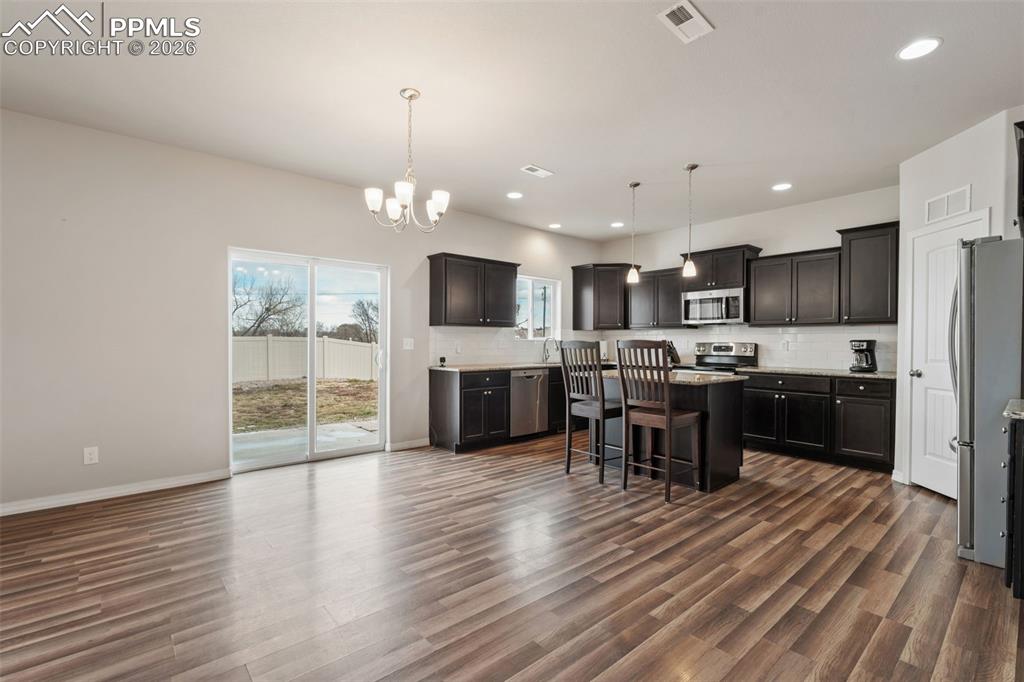 Image 17 of 50: Kitchen with a kitchen breakfast bar, backsplash, stainless steel appliance