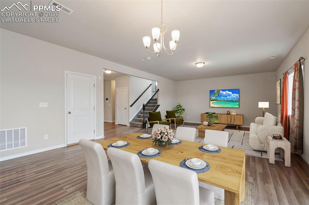 Image 18 of 50: Virtually staged. Dining room with a chandelier and dark wood finished floo