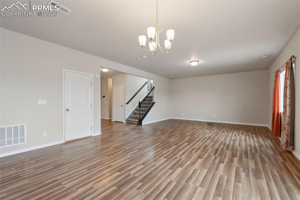 Image 19 of 50: Unfurnished living room with light wood-style floors and suspended lighting