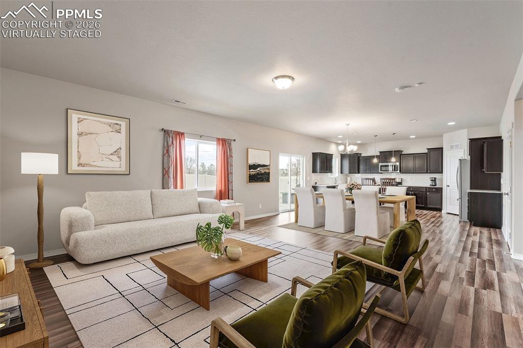 Image 2 of 50: Virtually staged. Living room with dark wood-style floors and suspended lig