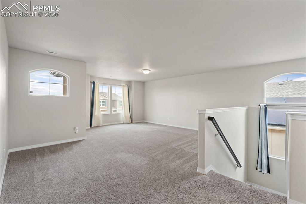 Image 28 of 50: Carpeted empty room with baseboards