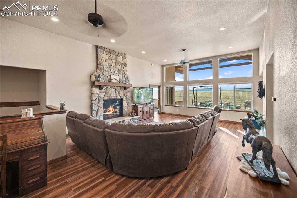 Image 5 of 49: a great room with a stately stone fireplace
