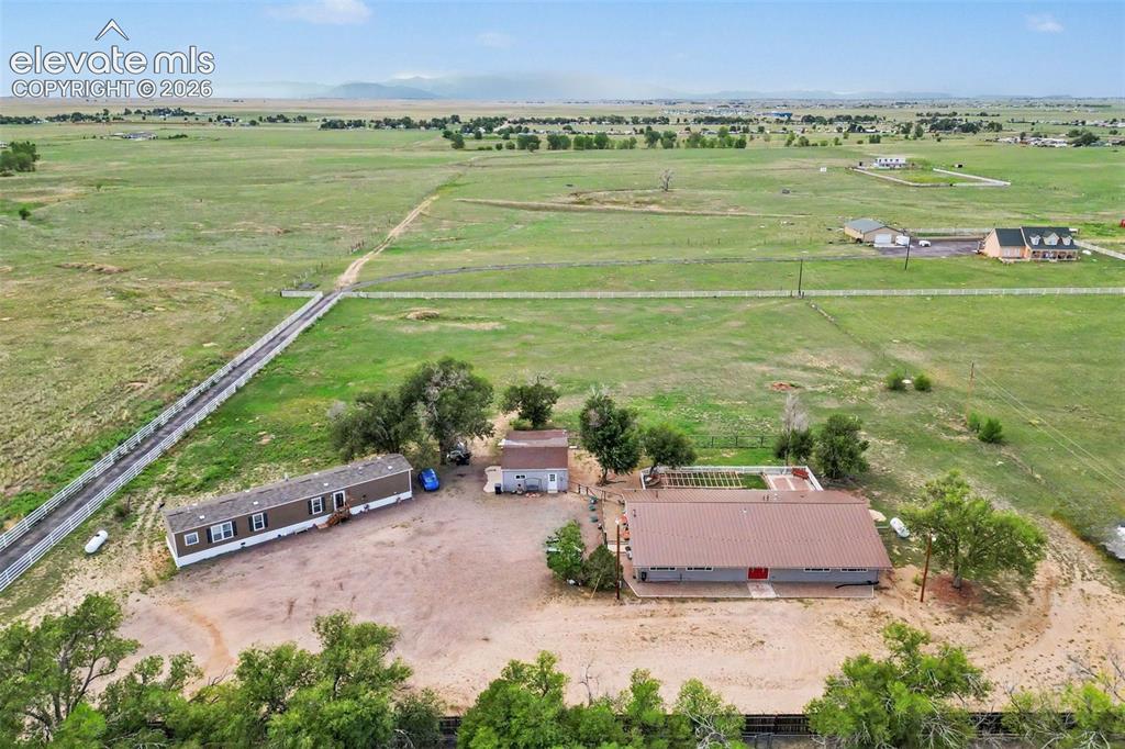 Caption: Stunning aerial perspective showcases the expansive property, two homes, abundant parking, open spac