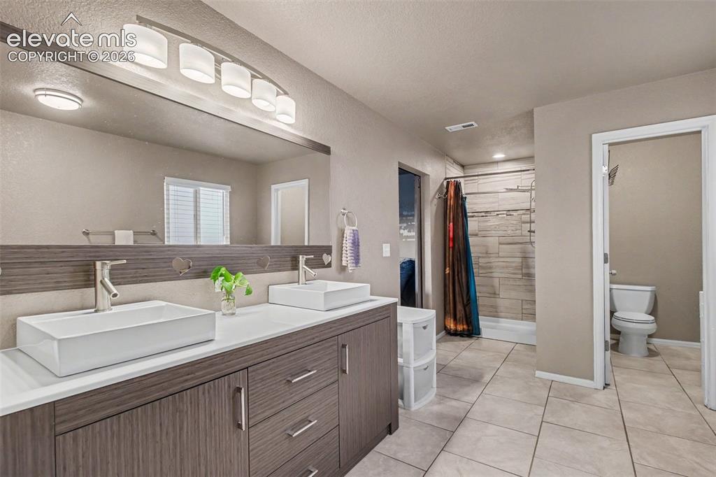 Image 17 of 45: Beautifully appointed primary 5-piece bathroom featuring dual sinks, a sep