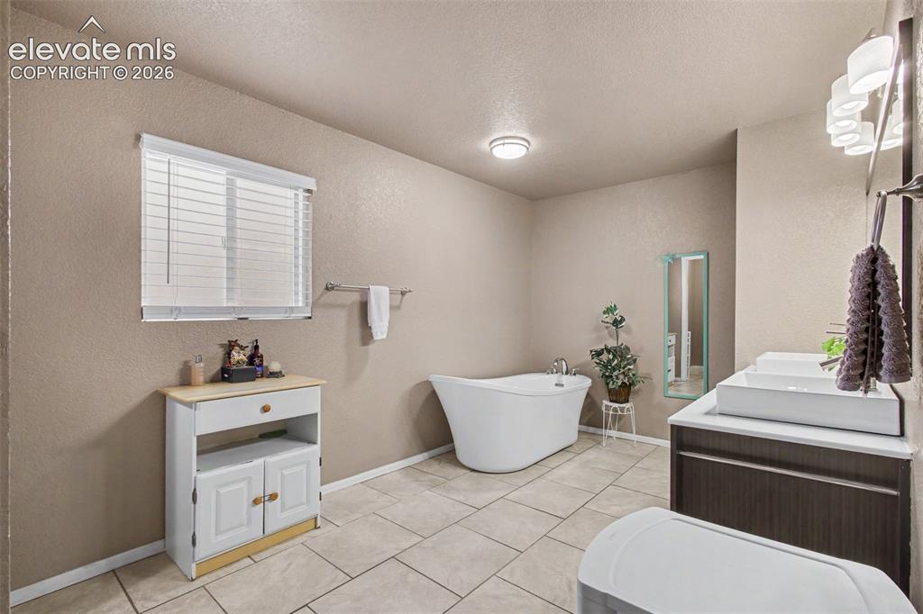 Image 18 of 45: Elegant freestanding soaking tub offers the perfect spot to relax, unwind,