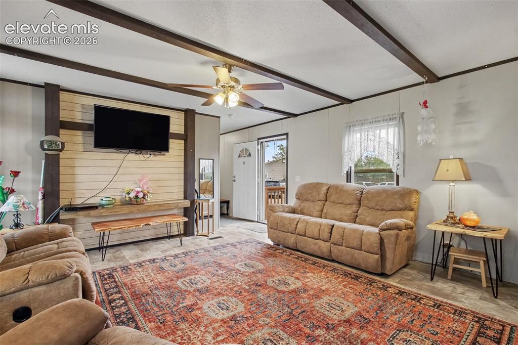 Image 28 of 45: 2nd Home: Cozy living room featuring a stylish accent wall, exposed beams,