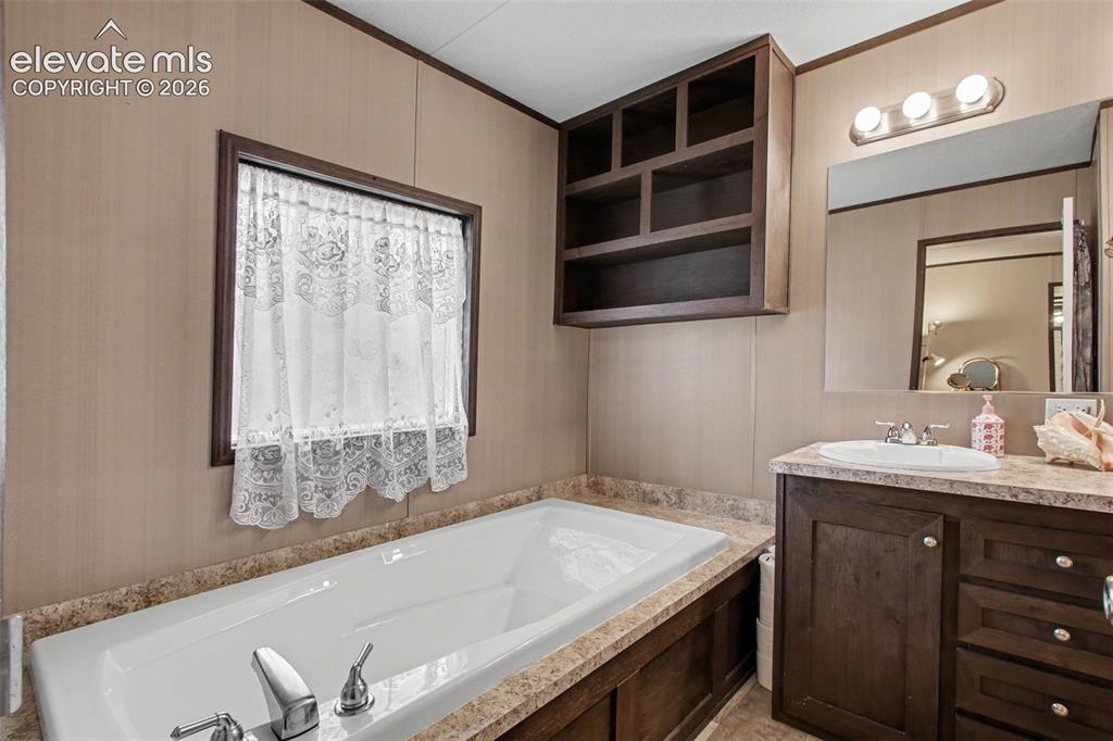 Image 35 of 45: 2nd Home: Primary bathroom featuring a tub with built-in shelving offering