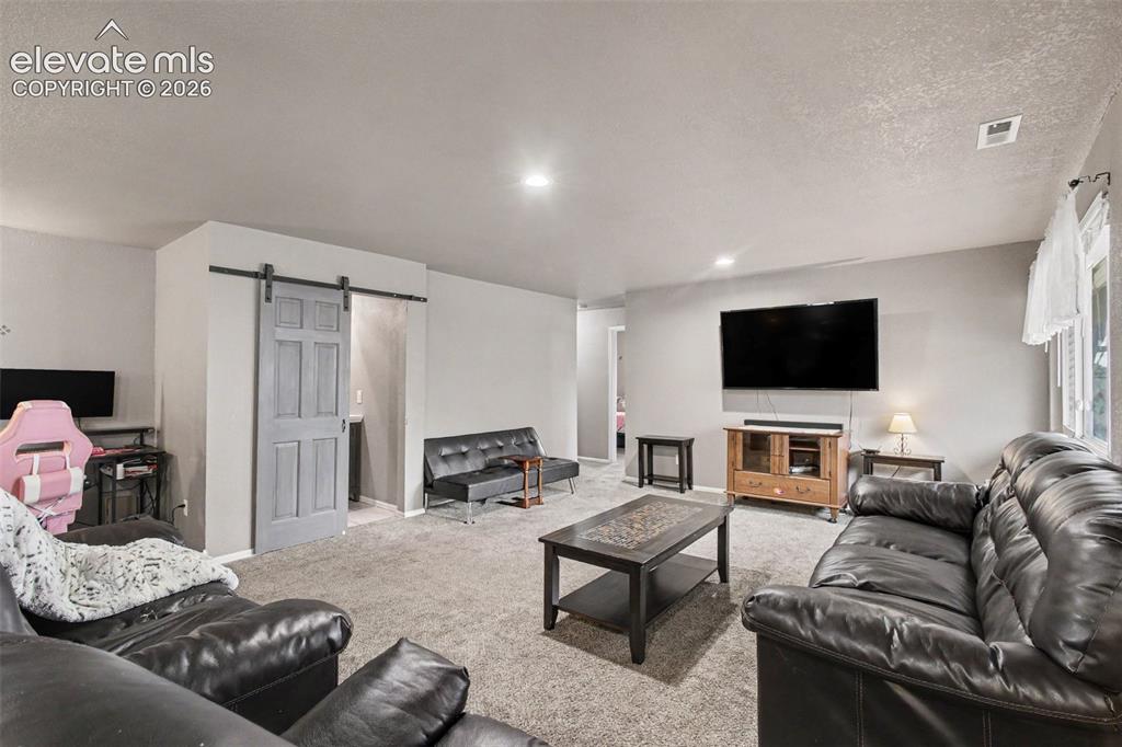 Image 9 of 45: Cozy and inviting living room conveniently located next to the bathroom, fe