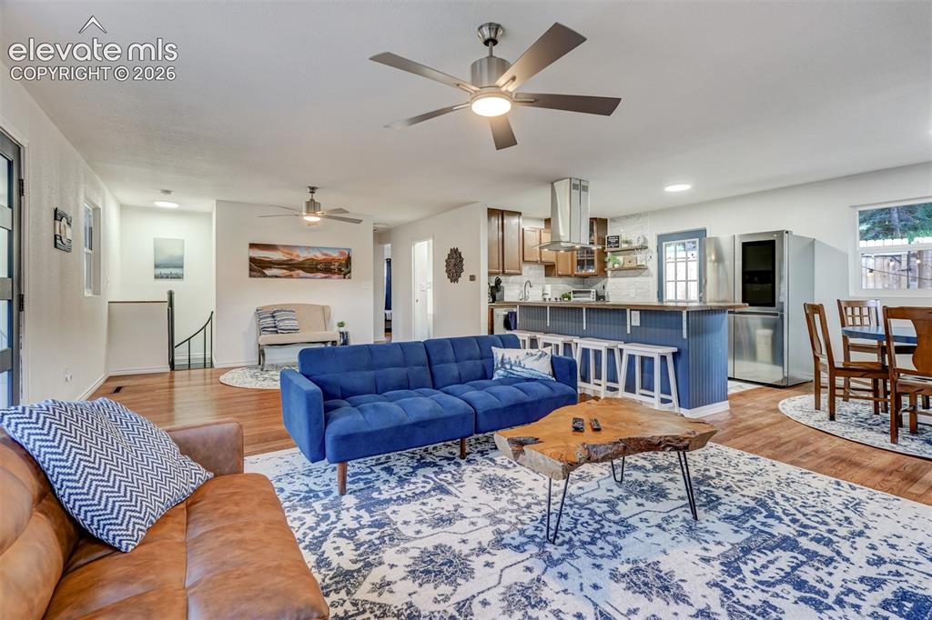 Image 11 of 41: Open-concept living space featuring wood-finish flooring, recessed lighting