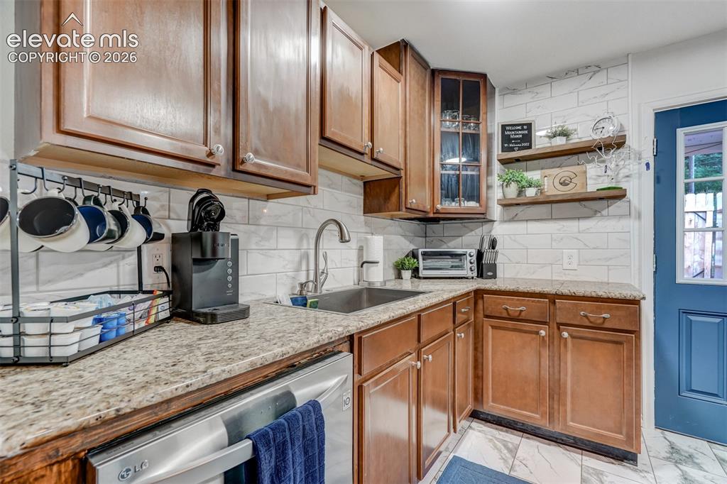 Image 18 of 41: Warm wood cabinetry with brushed nickel hardware and a light stone countert