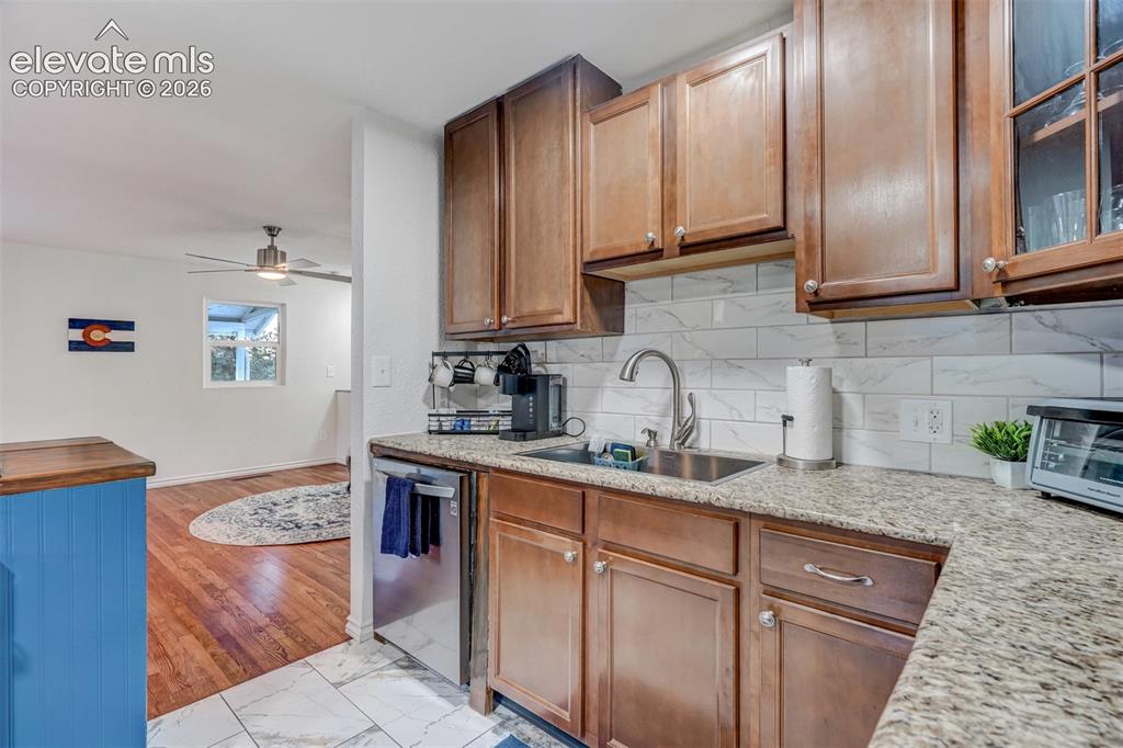 Image 19 of 41: Kitchen featuring wood-finish cabinetry, light-toned countertop, subway til