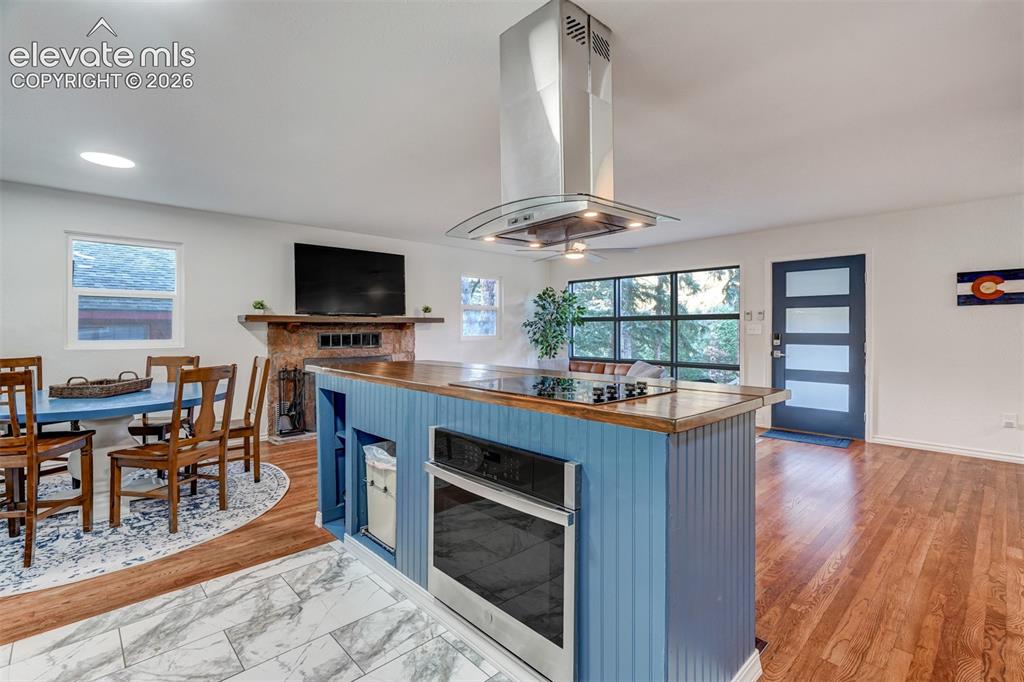 Image 21 of 41: Open-concept living space with hard-surface flooring, a built-in fireplace,