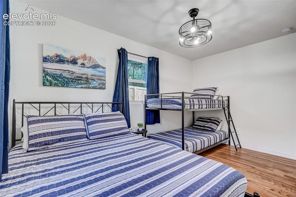 Image 26 of 41: Hardwood-style flooring, white walls, and a window with dark curtains