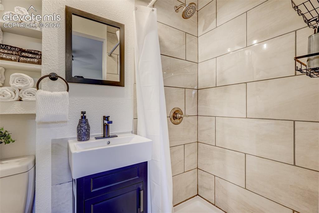 Image 30 of 41: White ceramic subway tile shower surround with bronze fixtures