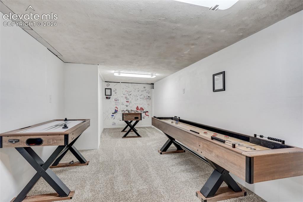 Image 34 of 41: Carpeted flooring throughout a recreation space with white walls and a text