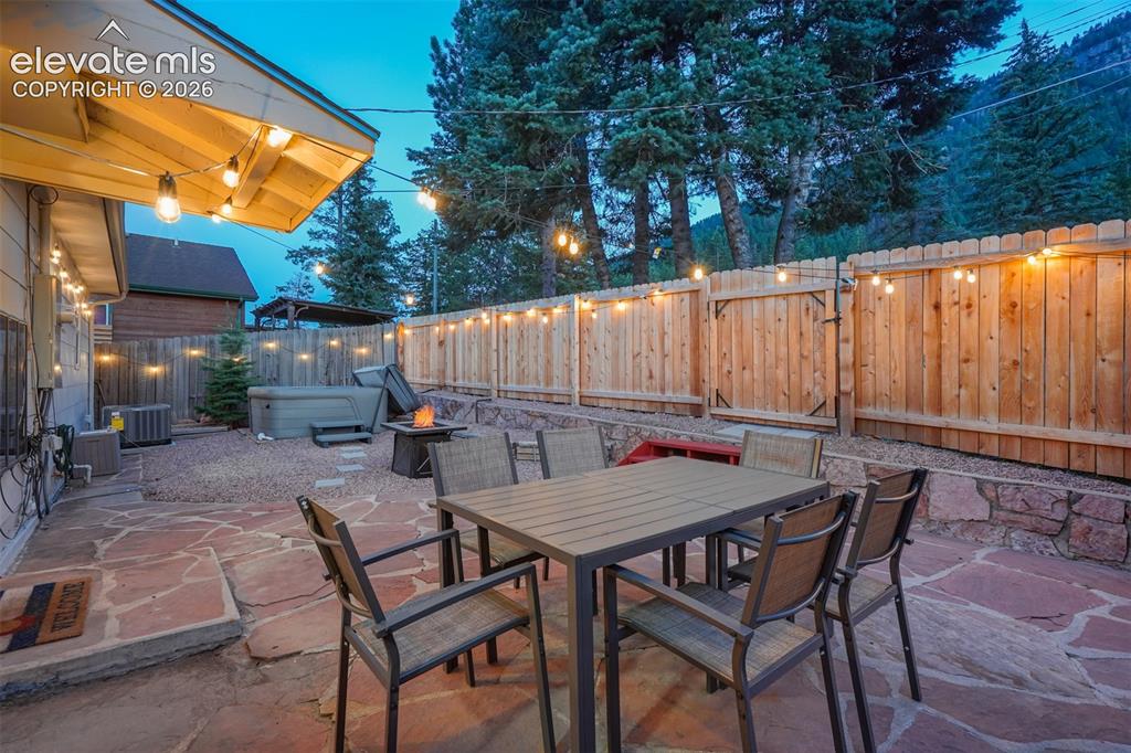 Image 5 of 41: Flagstone patio, privacy fencing, gravel landscaping, built-in hot tub, and