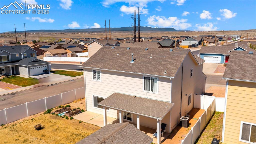 Image 9 of 37: Traditional home featuring a residential view, driveway, a garage, roof wit