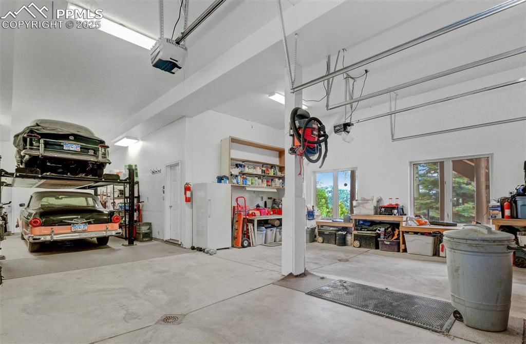 Image 34 of 46: Heated 4 car garage with car lift and workbench. 